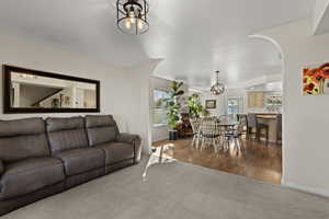 Living area featuring a chandelier, light carpet, and dark wood finished floors