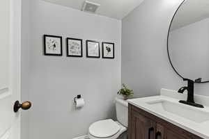 Half bathroom with a textured ceiling and vanity