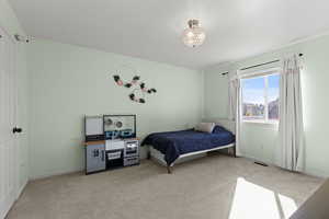 Carpeted bedroom featuring baseboards and a chandelier