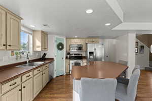 Kitchen with dark countertops, stainless steel appliances, dark wood-type flooring, recessed lighting, and a textured ceiling