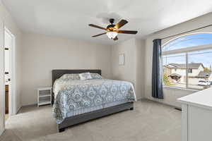 Bedroom with light carpet and a ceiling fan