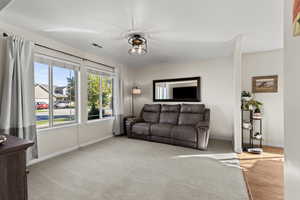 Living area featuring light colored carpet and baseboards