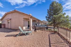 Back of property featuring stucco siding, a hot tub, a wooden deck, and a tiled roof