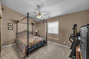 Bedroom featuring light carpet, a ceiling fan, a textured ceiling, and vaulted ceiling