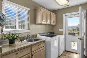 Laundry room with cabinet space, washer and dryer, and light tile patterned floors