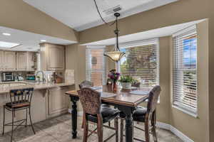 Dining space with vaulted ceiling and light tile patterned floors