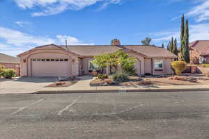 Mediterranean / spanish home featuring a tile roof, driveway, a chimney, an attached garage, and stucco siding