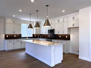 Kitchen featuring decorative light fixtures, tasteful backsplash, white cabinetry, and recessed lighting