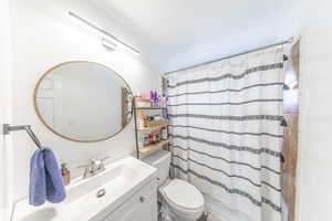 Bathroom featuring vanity and shower / bath combination with curtain
