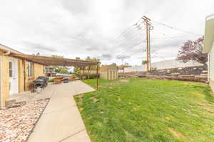 Fenced backyard featuring a storage unit and a patio area