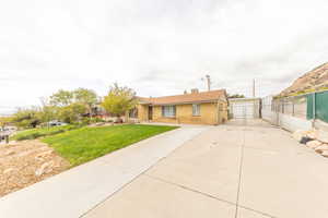 Ranch-style house featuring concrete driveway, brick siding, and a chimney
