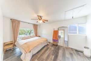 Bedroom featuring attic access, multiple windows, and wood finished floors