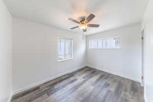 Unfurnished room with plenty of natural light, wood finished floors, and ceiling fan