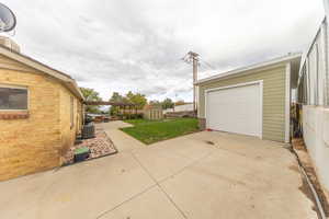 Garage with concrete driveway and a shed
