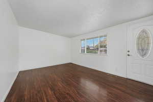 Entryway featuring dark wood-style flooring and baseboards