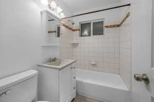 Bathroom featuring vanity, shower / washtub combination, and light tile patterned flooring