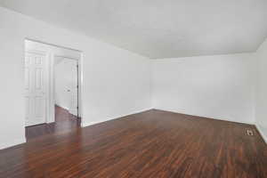 Spare room with dark wood finished floors and a textured ceiling
