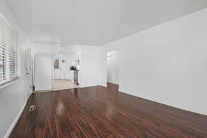 Unfurnished living room with light wood finished floors and baseboards