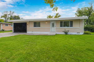 Ranch-style home with a front yard, brick siding, and concrete driveway