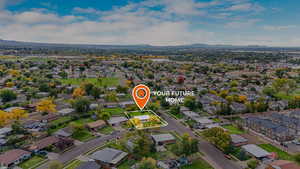 Aerial view of property's location featuring nearby suburban area, property parcel outlined, and a mountainous background
