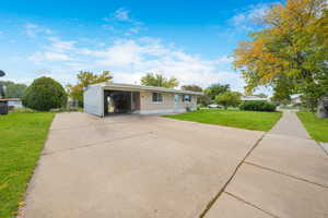 View of front facade featuring a front lawn, driveway, and brick siding