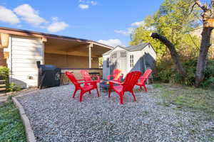 View of patio / terrace with an outdoor fire pit, a shed, and area for grilling