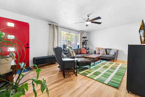 Living area featuring light wood-style flooring and a ceiling fan