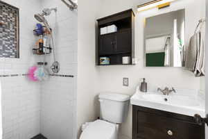 Full bathroom featuring a tile shower and vanity