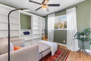 Living area with light wood finished floors and a ceiling fan