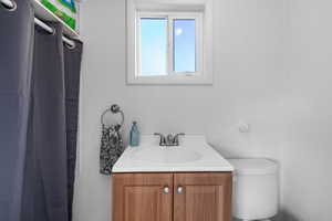 Full bathroom with vanity, a textured wall, and curtained shower