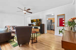 Living room with light wood-style flooring and ceiling fan
