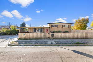 View of front of house featuring a fenced front yard and brick siding