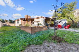 Back of house featuring a chimney, a patio area, and an outdoor structure
