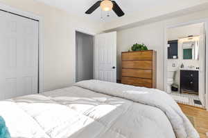 Bedroom featuring wood finished floors, a closet, a ceiling fan, and connected bathroom