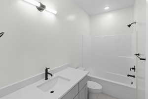 Bathroom featuring vanity, bathing tub / shower combination, and light tile patterned flooring