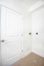 Laundry area featuring washer hookup, wood finished floors, and hookup for an electric dryer