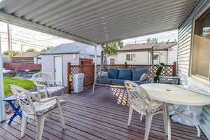 Wooden deck with outdoor lounge area, a storage unit, and outdoor dining space
