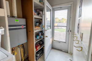 Entryway featuring water heater and tile patterned floors