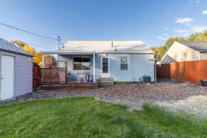 Rear view of property featuring a wooden deck and roof with shingles