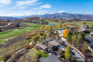Aerial view of residential area featuring a golf club and a water and mountain view