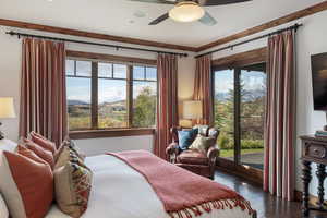 Bedroom featuring multiple windows, wood-type flooring, access to exterior, and a ceiling fan