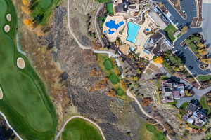 Aerial view of property and surrounding area featuring a local golf course and a pool