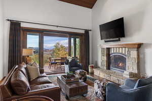 Living room featuring a fireplace, wood finished floors, high vaulted ceiling, and wooden ceiling