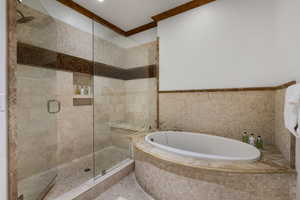Bathroom featuring a garden tub, tile walls, and a shower stall