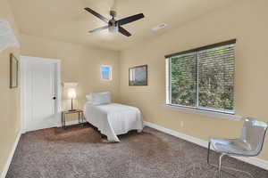 Carpeted bedroom featuring baseboards and ceiling fan