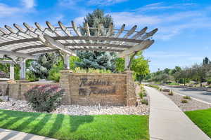 Community / neighborhood sign with a pergola and a lawn