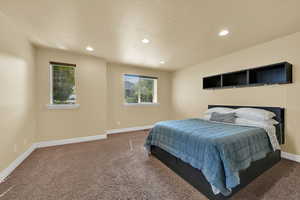 Bedroom with recessed lighting, carpet floors, and a textured ceiling
