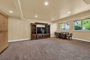 Living room featuring recessed lighting, light carpet, and beamed ceiling