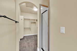 Walk in closet featuring light carpet and attic access