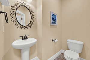 Half bathroom featuring toilet and tile patterned floors